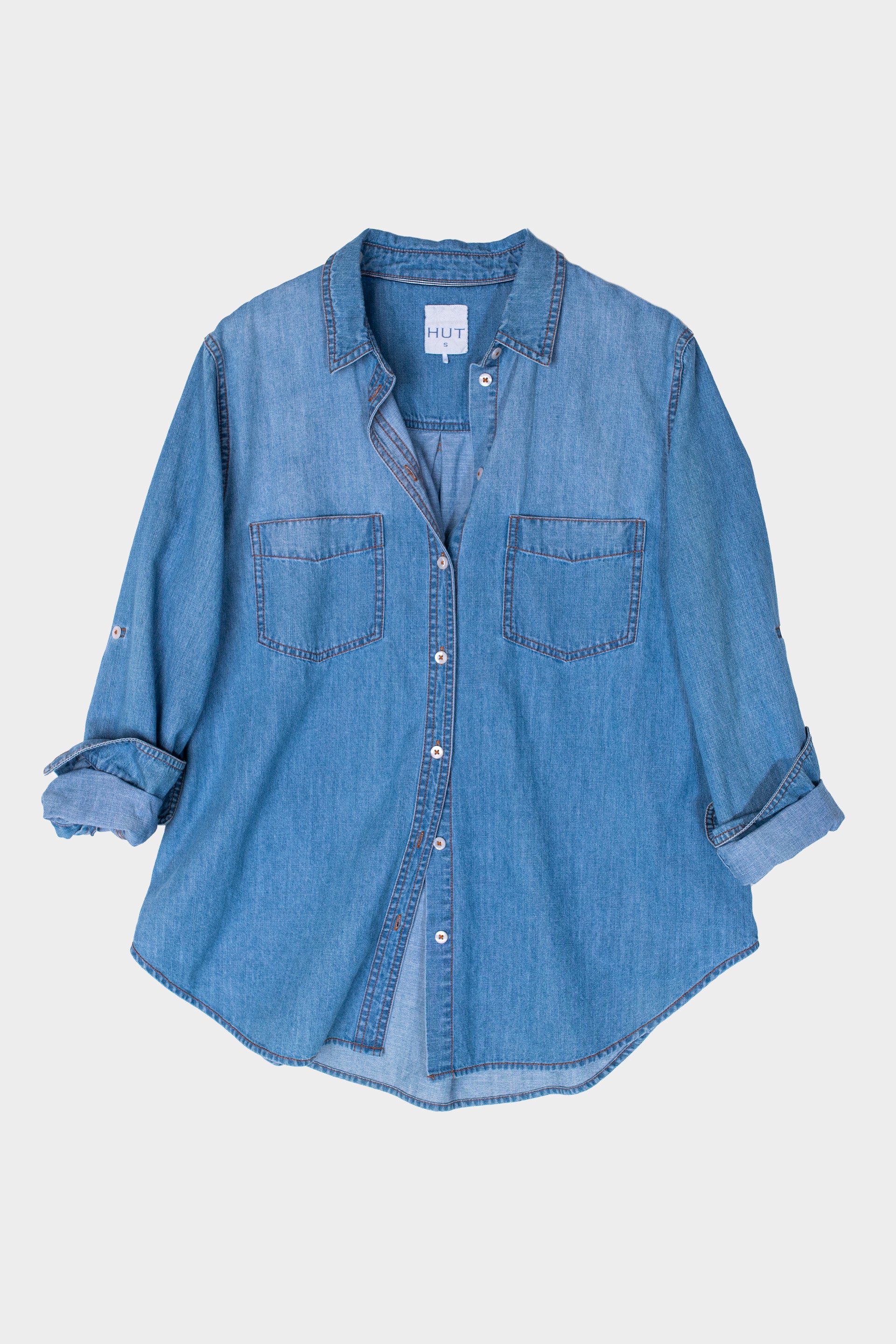 HUT Blue denim oversized shirt on a light gray background
