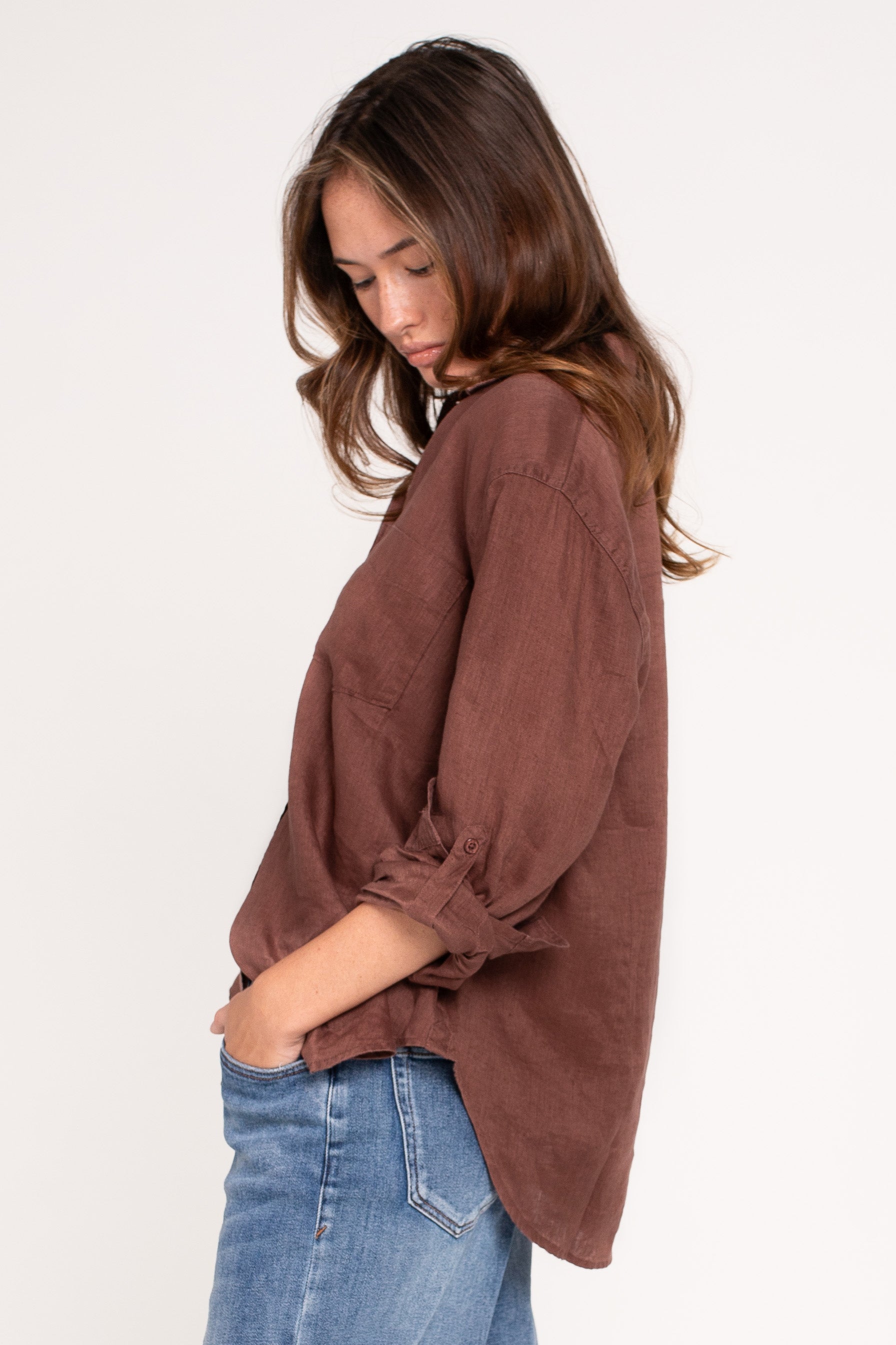 HUT Brown/Cinnamon Boyfriend linen shirt with tab sleeves and a scoop hem, paired with blue jeans.