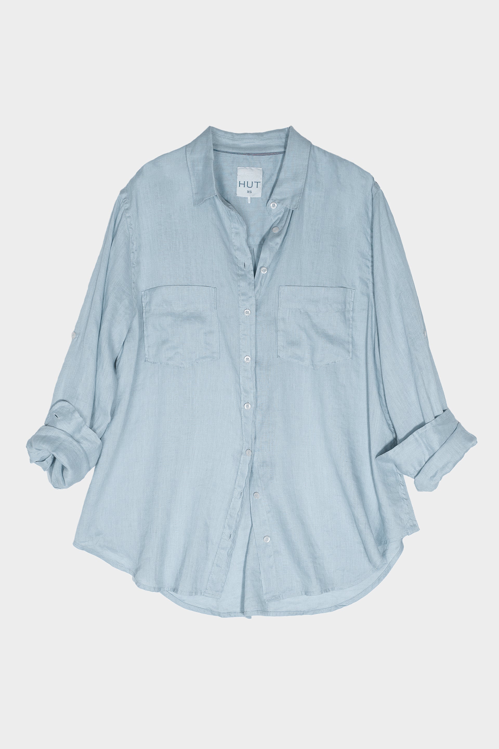 Light blue button-up linen boyfriend shirt with tab sleeves and two chest pockets on a white background