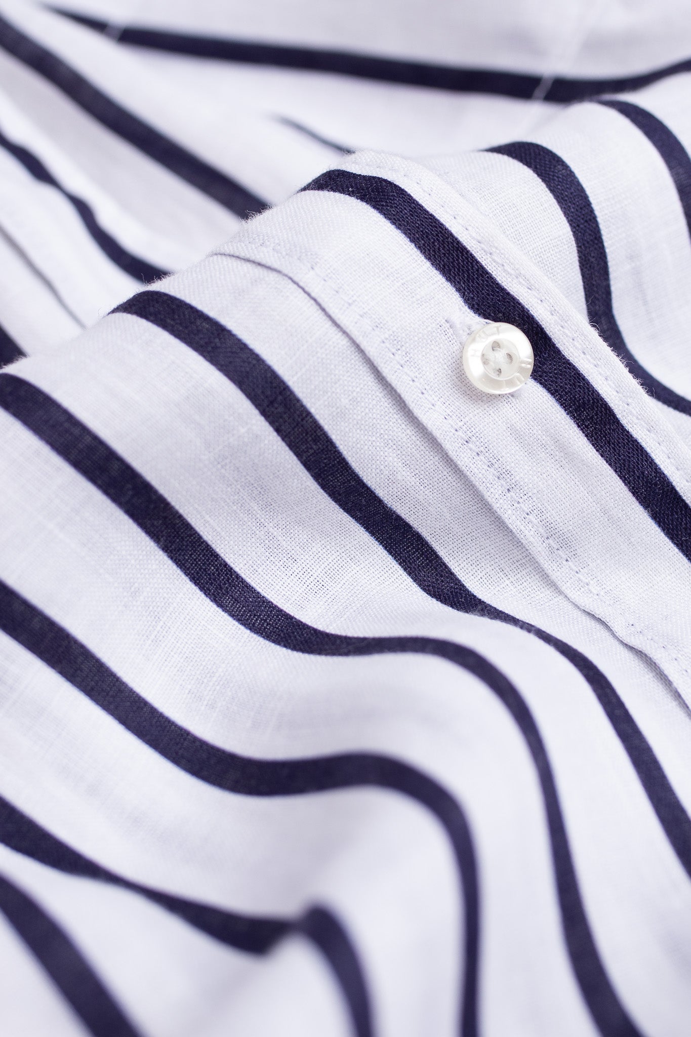 Close up of placket and Hut branded buttons on Hut Clothing Navy and White Stripe Boyfriend Linen Shirt