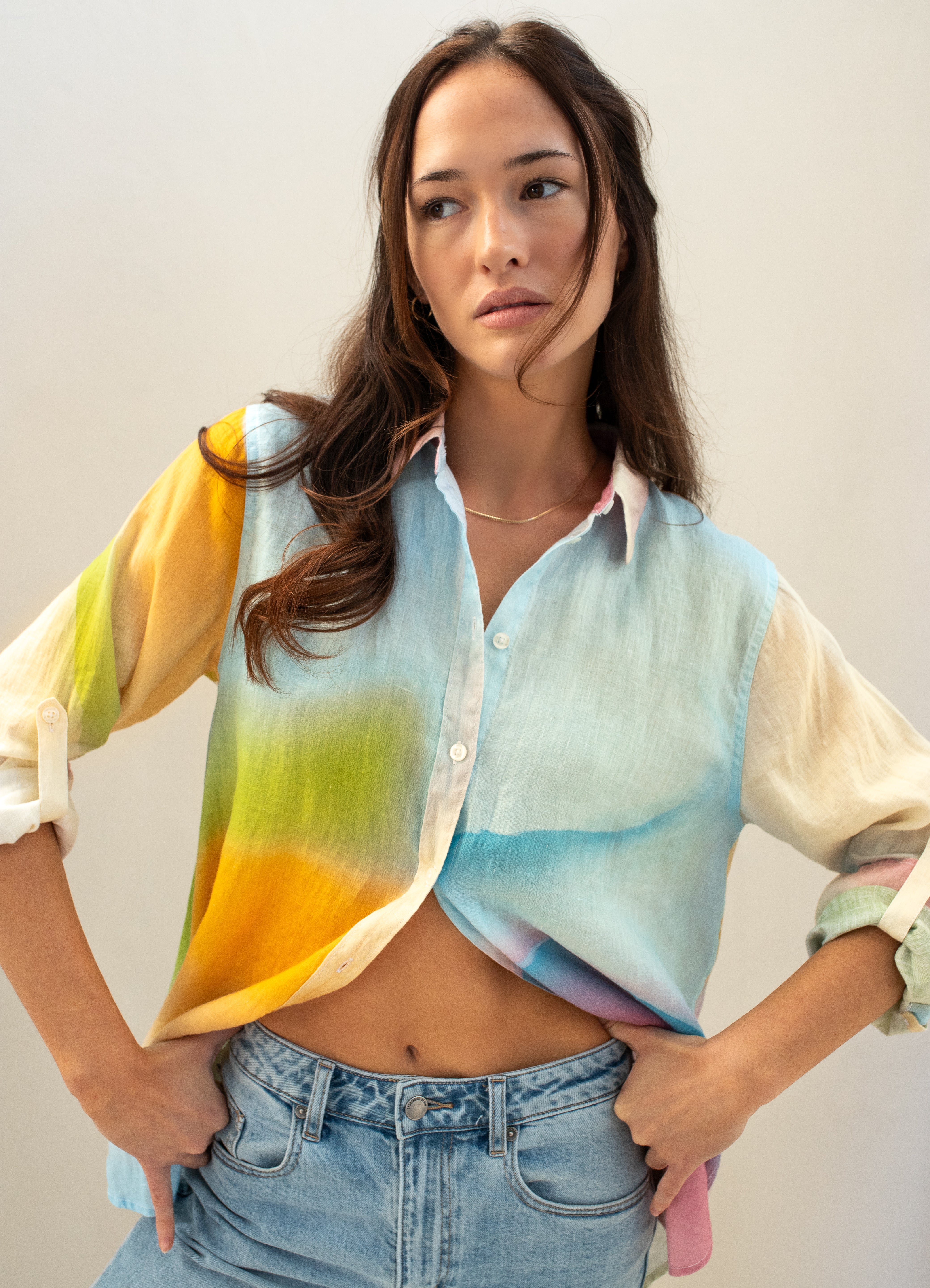 Model wearing a colorful line oversized boyfriend shirt with a gradient design against a plain background