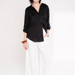 Model wearing Hut Clothing Black Embroidered Palm Boyfriend Linen Shirt made from organic Belgian linen and white pants