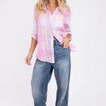 A woman wearing a Hut Clothing pink plaid boyfriend linen shirt with a oversized fit, paired with blue jeans.