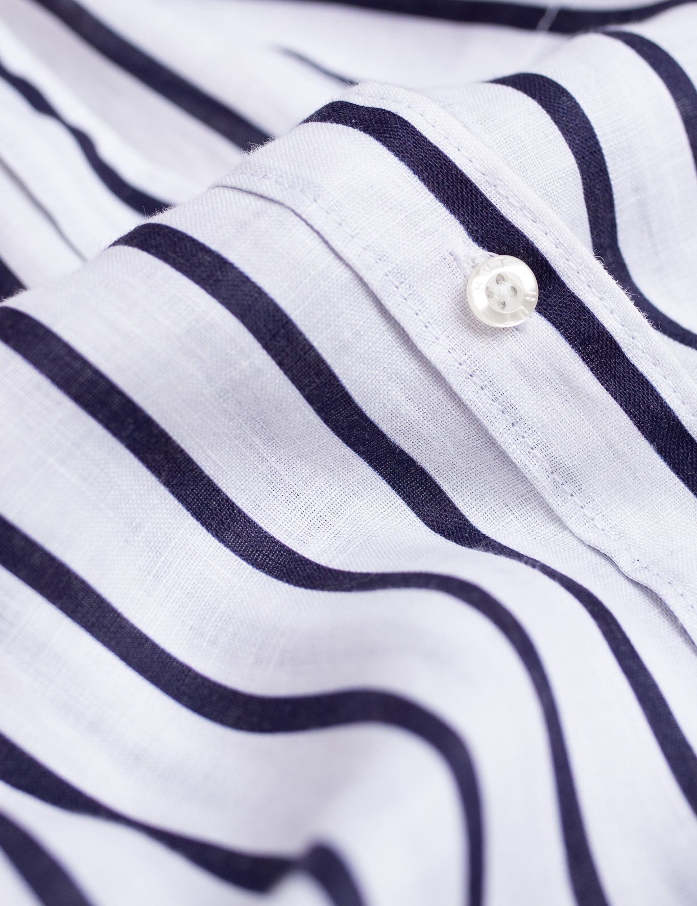 Close up of placket and Hut branded buttons on Hut Clothing Navy and White Stripe Boyfriend Linen Shirt