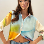 Model wearing a colorful line oversized boyfriend shirt with a gradient design against a plain background