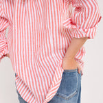 Model wearing a Hut red and white striped boyfriend linen shirt, paired with blue jeans.