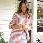 Lifestyle image of women drinking a coffee wearing Hut Rhubarb Stripe Boyfriend Linen Shirt